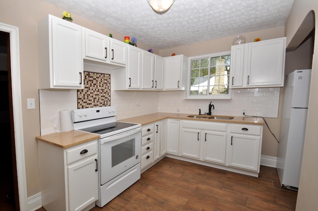 kitchen featuring dark wood finished floors, a sink, light countertops, white cabinets, and white appliances