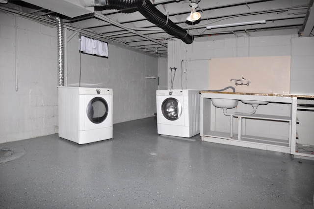 laundry area featuring laundry area, a sink, independent washer and dryer, and concrete block wall