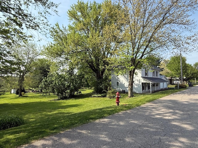 view of side of property with a yard and aphalt driveway