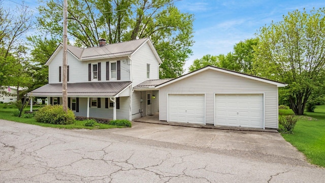 219 W Sheridan Ave, Somerset, OH 43783 - view of front of home featuring a garage, metal roof, a chimney, driveway, and covered porch