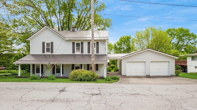 219 W Sheridan Ave, Somerset, OH 43783 - view of front of home with a porch, an outbuilding, a chimney, metal roof, and a detached garage