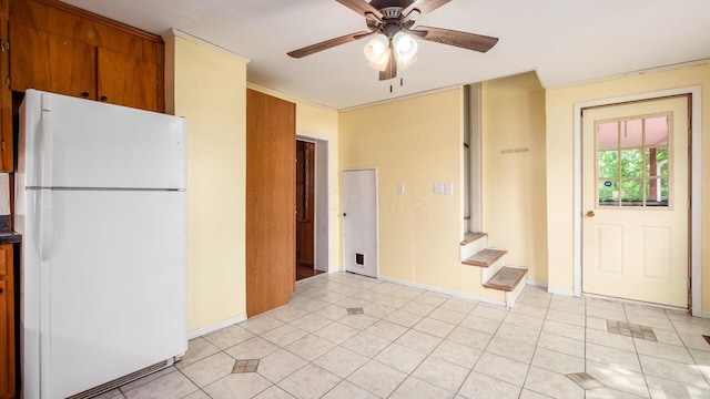 219 W Sheridan Ave, Somerset, OH 43783 - kitchen featuring freestanding refrigerator, a ceiling fan, light tile patterned floors, brown cabinetry, and dark countertops
