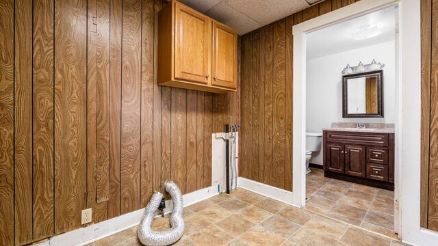 219 W Sheridan Ave, Somerset, OH 43783 - washroom featuring hookup for an electric dryer, cabinet space, wooden walls, and baseboards