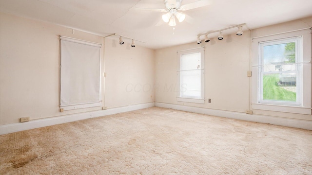 219 W Sheridan Ave, Somerset, OH 43783 - unfurnished room with rail lighting, plenty of natural light, ceiling fan, and light carpet