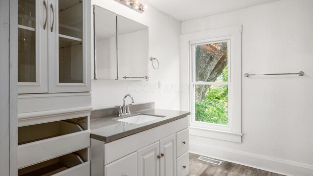 219 W Sheridan Ave, Somerset, OH 43783 - kitchen featuring a sink, white cabinetry, glass insert cabinets, wood finished floors, and dark countertops