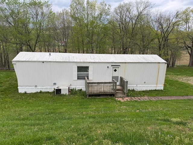 exterior space with a front lawn, a deck, and cooling unit