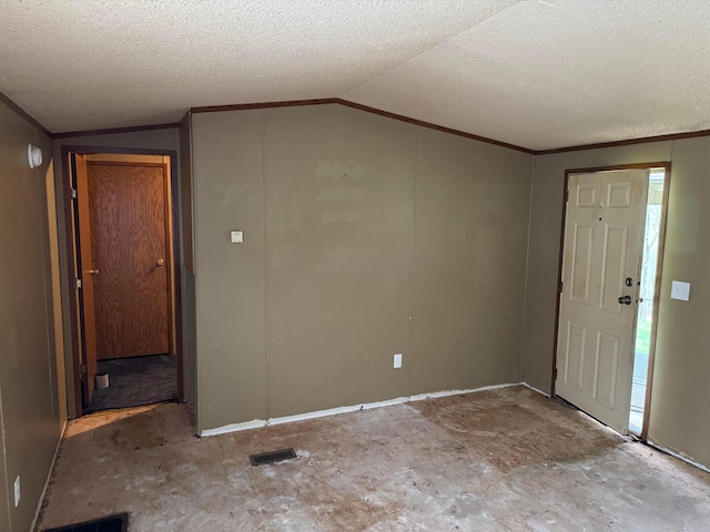 entryway featuring a textured ceiling, visible vents, ornamental molding, and lofted ceiling