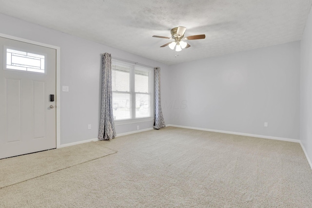carpeted foyer entrance with baseboards, ceiling fan, and a wealth of natural light