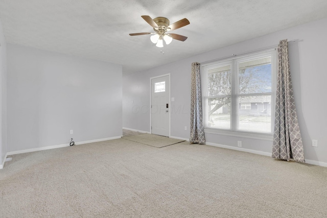 interior space with baseboards, ceiling fan, and carpet