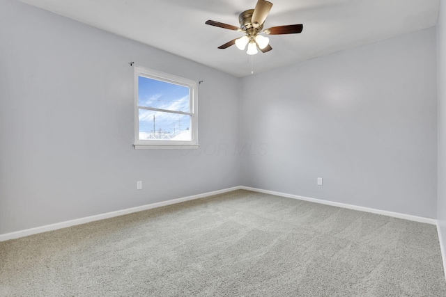 carpeted empty room featuring baseboards and ceiling fan