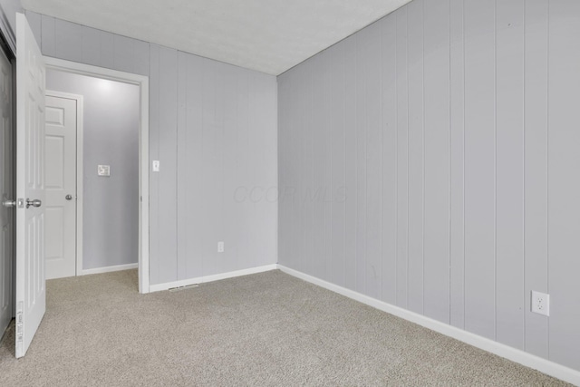 carpeted spare room featuring baseboards