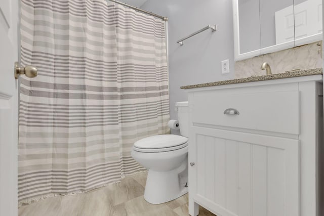 full bath featuring backsplash, toilet, curtained shower, and vanity