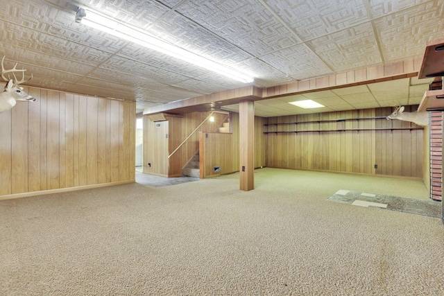 finished below grade area with wooden walls, carpet flooring, and stairway