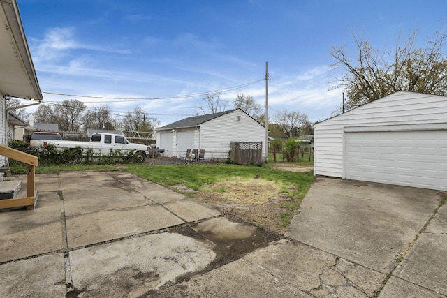 exterior space featuring a detached garage, fence, and an outdoor structure