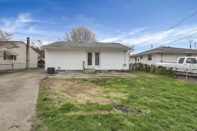 rear view of house featuring french doors, fence, a yard, and central AC