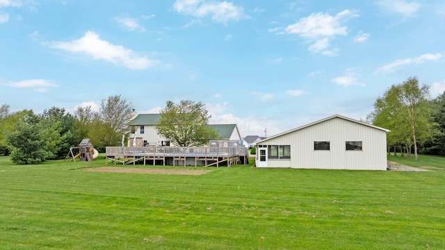 back of property featuring a yard, a deck, and a playground