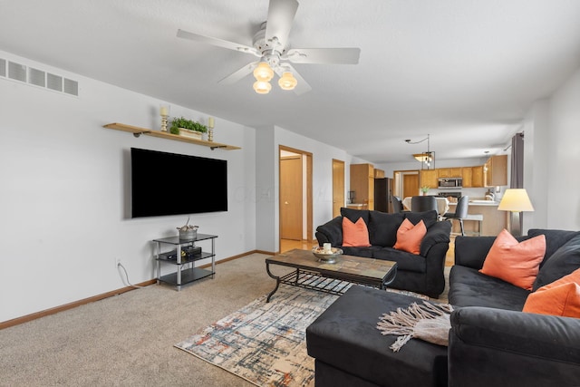 living area with baseboards, light carpet, visible vents, and a ceiling fan