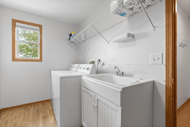 laundry area featuring baseboards, light wood-style floors, and washer and dryer