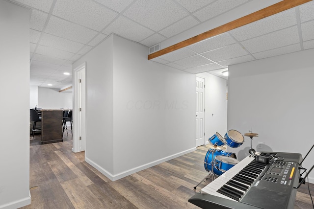 hallway featuring wood finished floors, a paneled ceiling, visible vents, baseboards, and recessed lighting