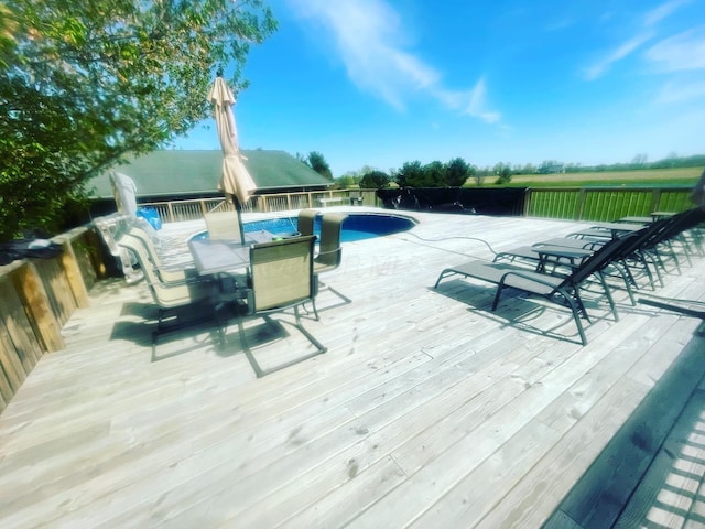 view of swimming pool featuring outdoor dining area, a wooden deck, and a fenced in pool
