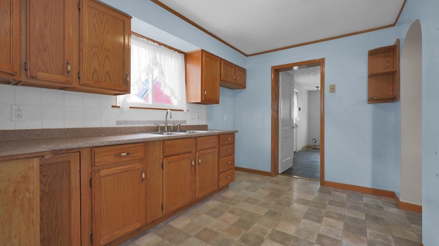 74 S Chester St, West Jefferson, OH 43162 - kitchen with a sink, brown cabinetry, stone finish floor, baseboards, and tasteful backsplash