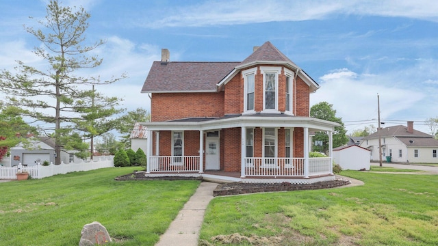 74 S Chester St, West Jefferson, OH 43162 - victorian home with covered porch, a chimney, a front yard, and brick siding