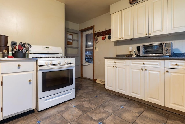 1234 E Fair Ave, Lancaster, OH 43130 - kitchen featuring white range with gas cooktop, dark tile patterned floors, a toaster, white cabinets, and dark countertops