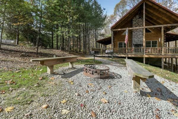 exterior space with an outdoor fire pit, a deck, and log siding