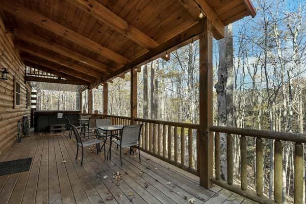 wooden deck featuring outdoor dining area and a hot tub