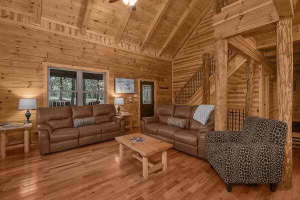 living area with wood ceiling, wood walls, wood finished floors, high vaulted ceiling, and beamed ceiling