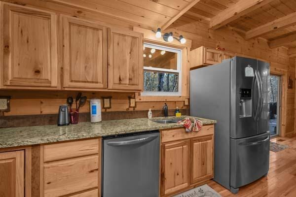kitchen with wood walls, light brown cabinets, wood ceiling, light wood finished floors, and appliances with stainless steel finishes