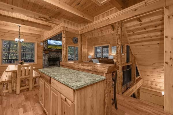 kitchen with wood walls, beamed ceiling, light wood-style floors, open floor plan, and wooden ceiling