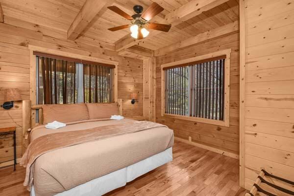 bedroom with wood finished floors, wood walls, beam ceiling, and wooden ceiling
