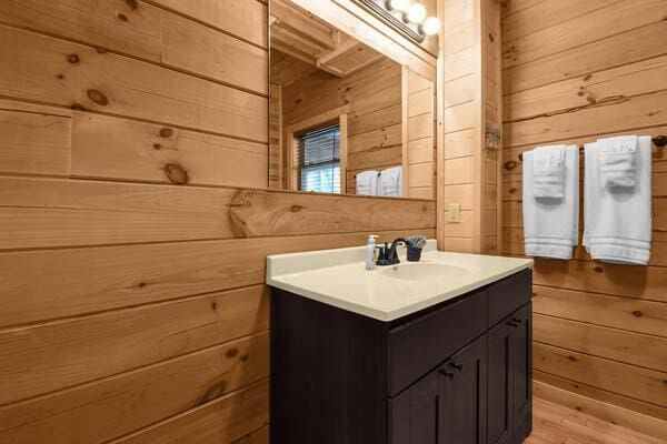 bathroom featuring vanity and wood walls