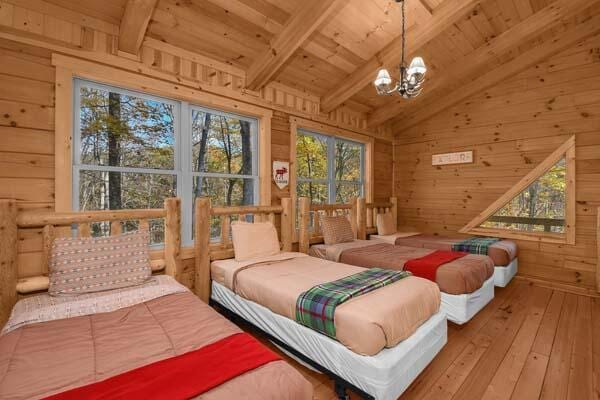 bedroom with wooden walls, wooden ceiling, hardwood / wood-style flooring, and a chandelier