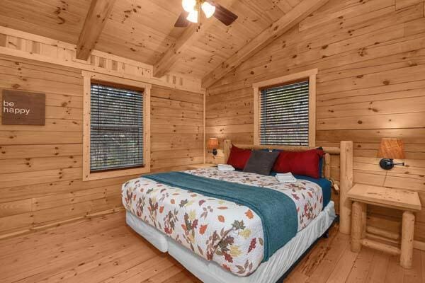 bedroom with wood walls, lofted ceiling with beams, wooden ceiling, and hardwood / wood-style flooring