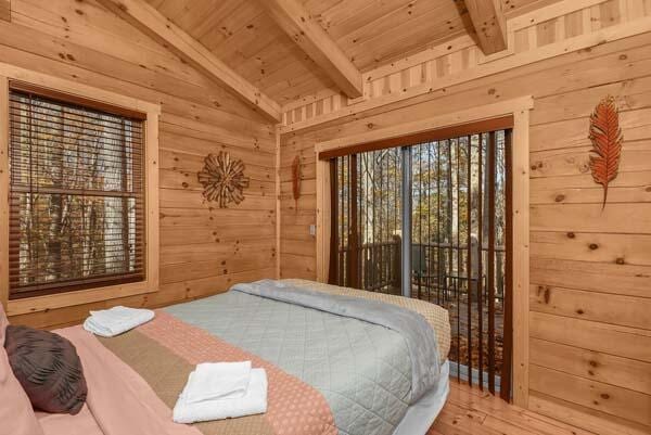 bedroom featuring wood walls, wood finished floors, access to exterior, wooden ceiling, and lofted ceiling with beams
