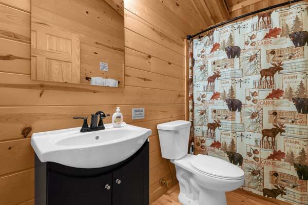full bath with vanity, wood walls, toilet, and wood finished floors