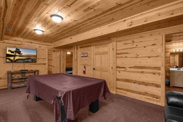 recreation room featuring wooden walls, pool table, carpet, and wood ceiling