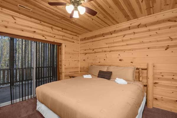 bedroom with carpet floors, wooden walls, wooden ceiling, and access to exterior