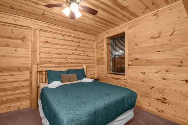 bedroom featuring carpet floors, a ceiling fan, wooden walls, and wooden ceiling
