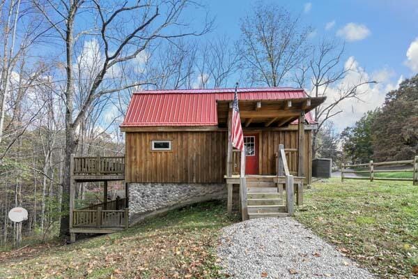 view of outbuilding with central air condition unit and fence