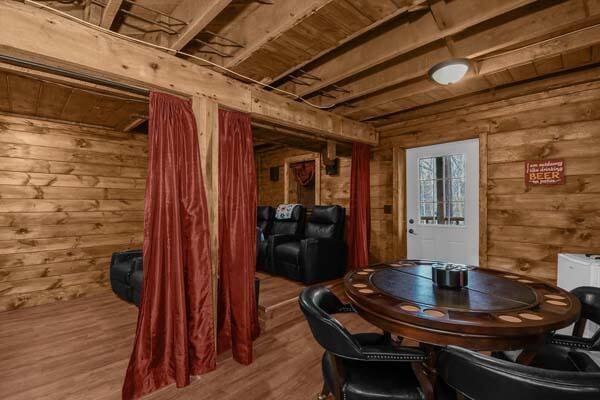 dining room with wooden walls and wood finished floors