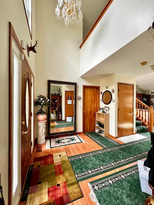 785 Lone Rise Dr E, Marysville, OH 43040 - foyer entrance with stairway, a high ceiling, wood finished floors, and a notable chandelier