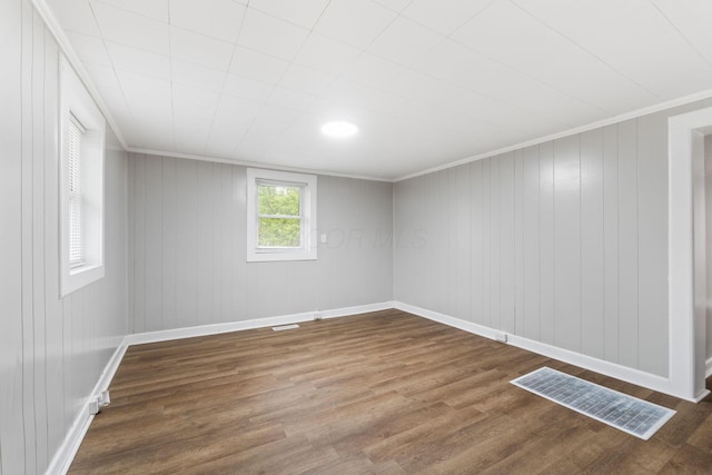 spare room with dark wood finished floors, baseboards, and crown molding