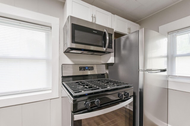 kitchen featuring appliances with stainless steel finishes, white cabinetry, and wood finished floors
