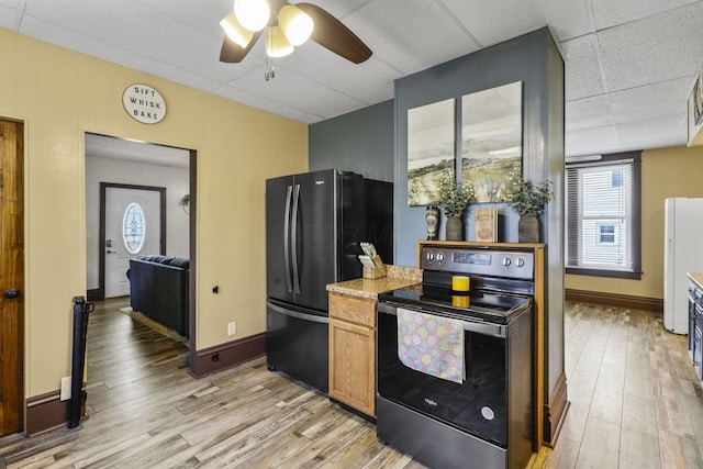 kitchen featuring light wood-style floors, freestanding refrigerator, a ceiling fan, and electric range