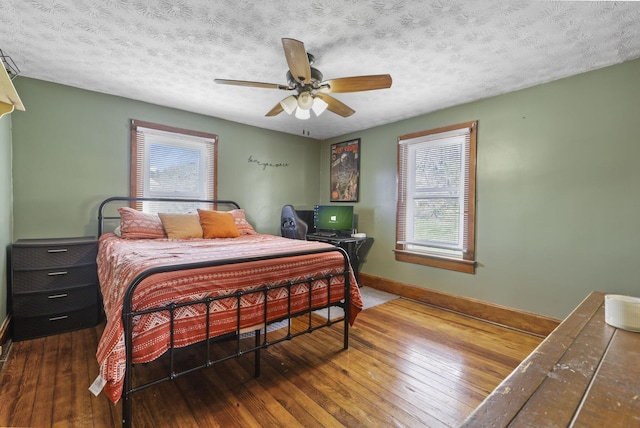 bedroom with baseboards, a ceiling fan, a textured ceiling, and hardwood / wood-style flooring