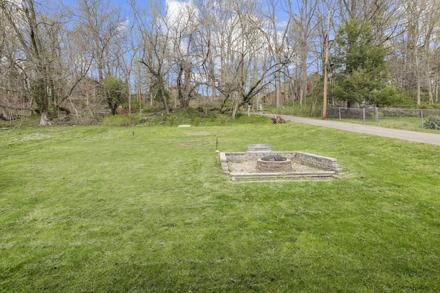 view of yard with an outdoor fire pit and fence