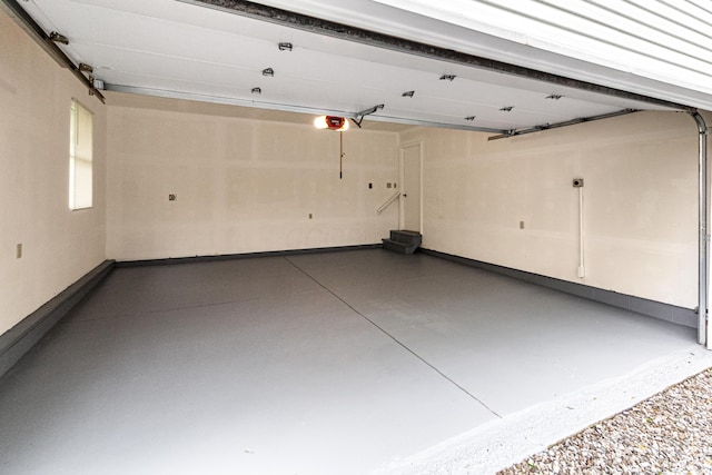 garage with baseboards and a garage door opener